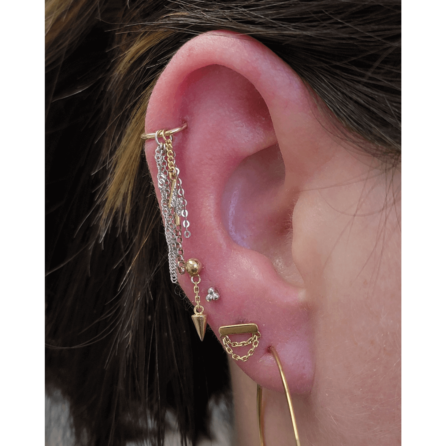 Ear curation done with a mix of white and yellow gold